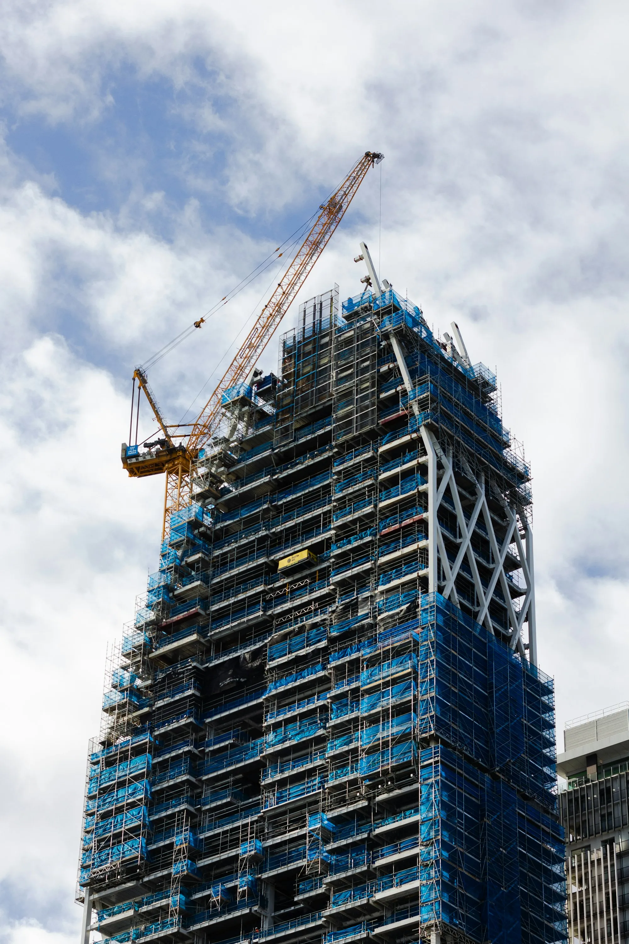 A tower crane beside a high-rise under construction in Auckland